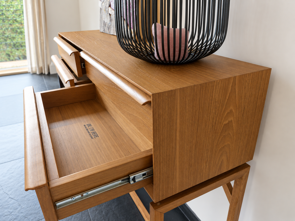 Detail van de geopende lade en metalen ladegeleider van de teak sidetable