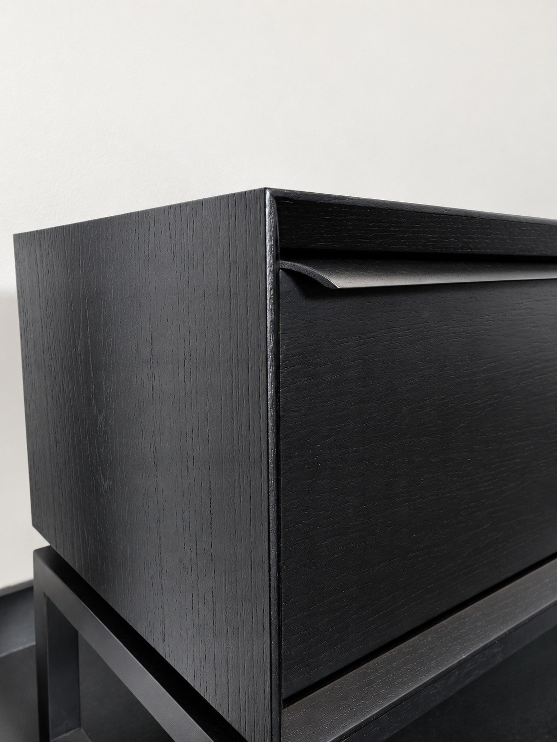 Detail van de houtstructuur en handgreep van het zwarte Ktwo Home tv-meubel